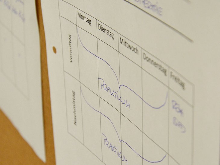 es ist ein Einsatzplan für Praktika zu erkennen welcher an einer Pinnwand angeheftet ist.