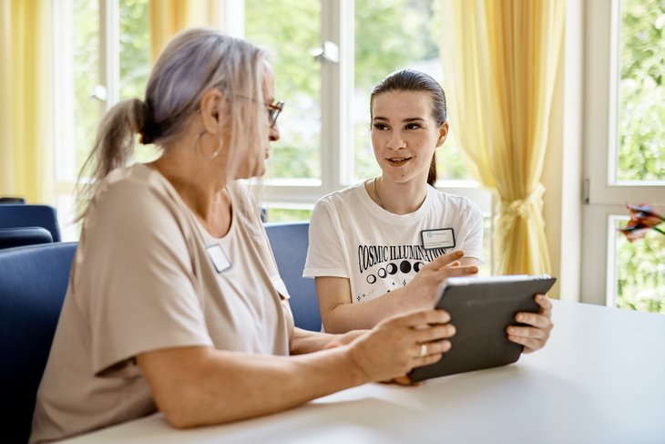 Praxisanleiterin erklärt Schülerin etwas am Tablet