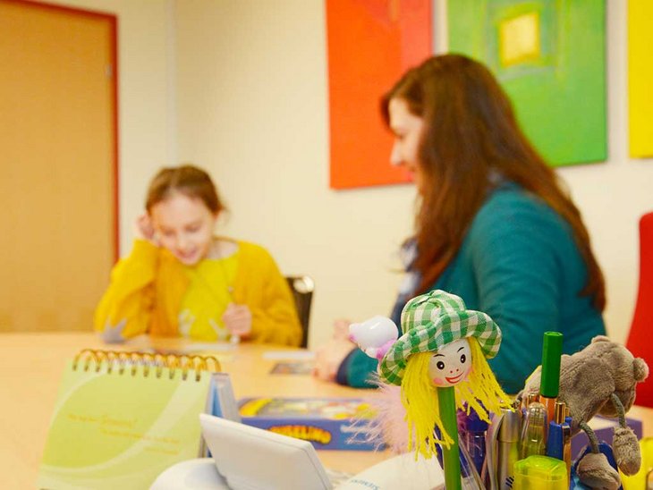 Man sieht eine erwachsene Frau mit einem jungen Mädchen in einer Gesprächssituation 