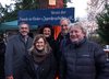 Der Vorstand des Fördervereins im Gruppenbild, dahinter ein blaues Schild mit der Aufschrift: "Verein der Freunde der Kinder- und Jugendpsychiatrie e.V."