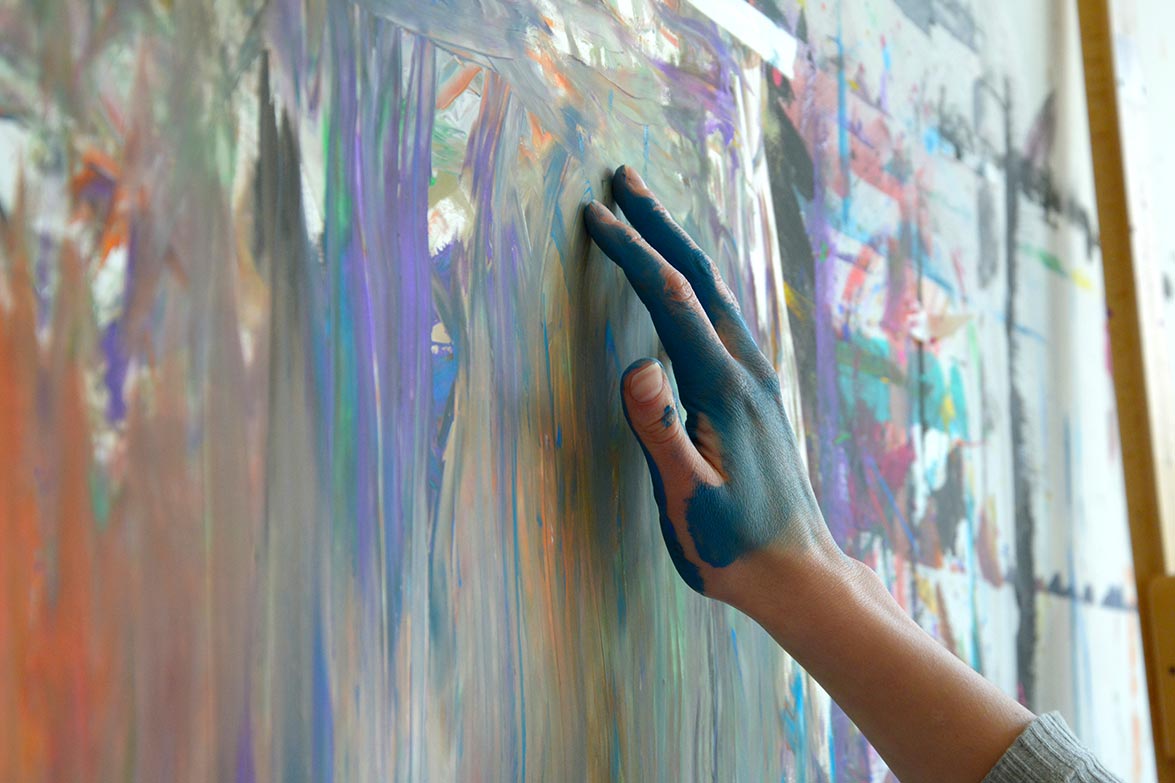 farbige Leinwand mit malender Hand 